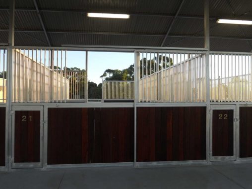 Front of open back stables with sliding entrance doors