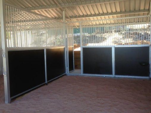 Stalls lined with black form ply large feed door access to back
